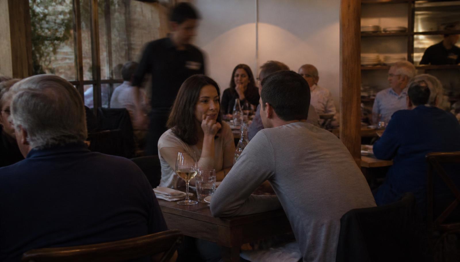 Gastvrije eigenaar achter de bar van een druk restaurant